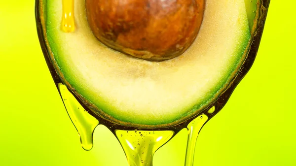 Fresh cut avocado with oil stream. — Stock Photo, Image