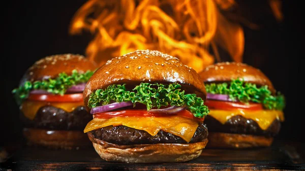 Gustosi cheeseburger, distesi su tagliere vintage in legno. — Foto Stock