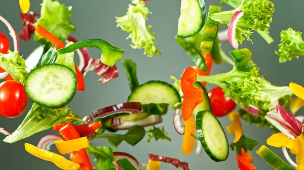 Flying vegetable salad isolated on grey background.