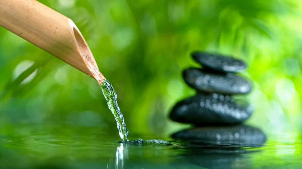 Leaking water stream from bamboo, spa and wellness concept.