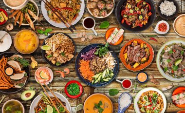 Kırsal ahşap arka planda çeşitli malzemeler içeren Asya yemekleri, üst görünüm.