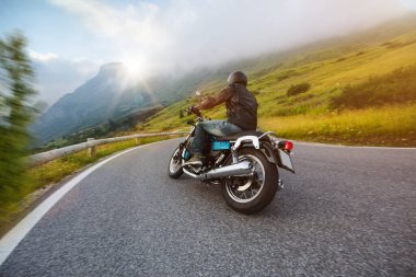 Motorcycle driver riding in Dolomite pass, Italy, Europe. clipart