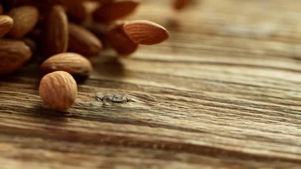 Amandes tombant et roulant sur une table. Tourné avec une caméra cinématographique à grande vitesse. Mouvement lent . — Video