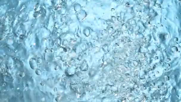 Agua salpicando sobre fondo azul, super cámara lenta. Filmado en cámara de cine de alta velocidad. — Vídeo de stock