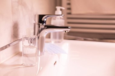 Lavabosu ve dezenfekte sıvısı olan modern banyo.