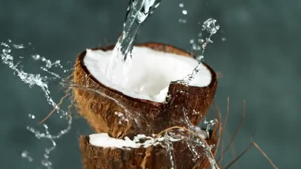 Langsame Bewegung des Wassers, das auf Kokosnuss spritzt — Stockvideo