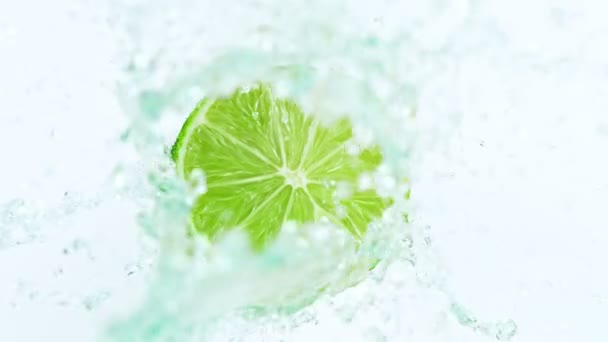 Super Zeitlupe Schuss von Limettenfrüchten mit Spritzwasser isoliert auf weißem Hintergrund — Stockvideo