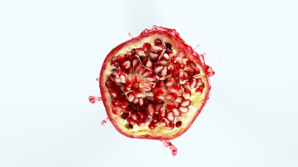 Super Zeitlupe Schuss Granatapfelfrucht mit Spritzsaft isoliert auf weißem Hintergrund — Stockvideo