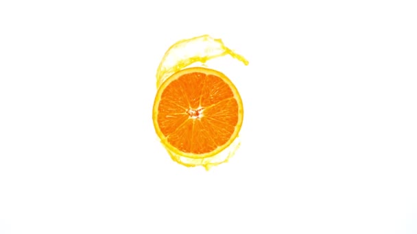 Super Slow Motion Shot de rodaja de naranja con zumo de chapoteo aislado sobre fondo blanco — Vídeos de Stock