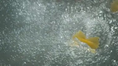 Makarnayı kaynamış suya atmak, ağır çekim..