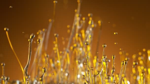 Super Slow Motion Shot of Splashing Oil sobre fondo dorado a 1000fps. — Vídeos de Stock