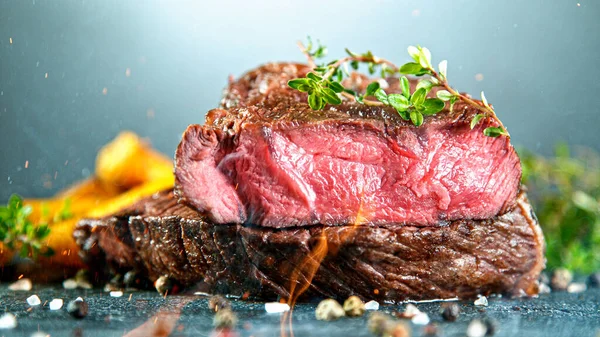 Primer plano de sabroso bistec de res en la mesa de piedra negra —  Fotos de Stock