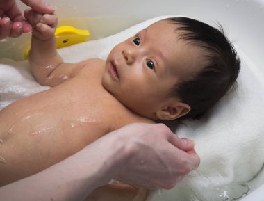 Küçük bebek banyo ve anne eline alarak
