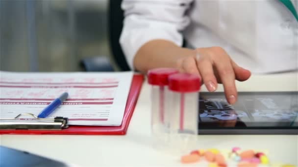Dokter onderzoekt een röntgenfoto van de patiënt op Tablet PC — Stockvideo