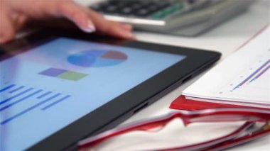 Diyagramları ile dijital Tablet üzerinde çalışan iş kadını. İş analiz raporu ekranda