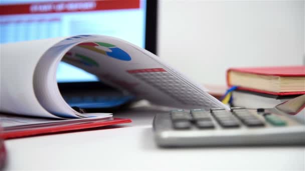 Schreibtisch im Büro mit Geschäftsgegenständen, Börsenstatistiken, Laptop, Stift und roter Brille — Stockvideo