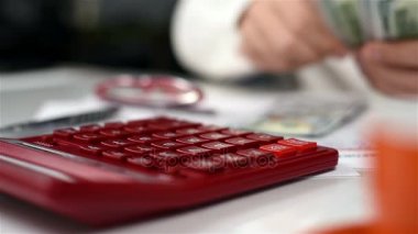 Muhasebeci adam hesap makinesi ile dolar sayar. Bankacılık kavramı. Yakın çekim