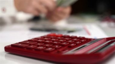 Muhasebeci adam hesap makinesi ile dolar sayar. Bankacılık kavramı. Yakın çekim