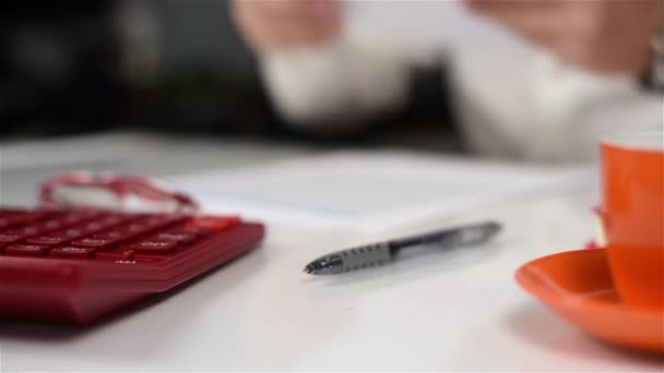 Zakenman verzamelt documenten op tafel en een financieel verslag schrijft — Stockvideo