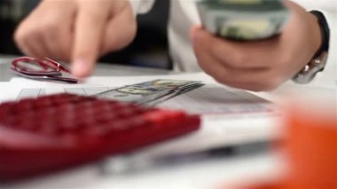 Muhasebeci adam hesap makinesi ile dolar sayar. Bankacılık kavramı. Yakın çekim