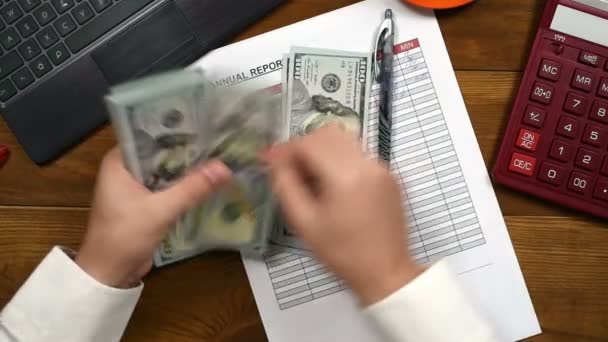Бухгалтер считает долларовые счета и пишет в финансовом отчете — стоковое видео