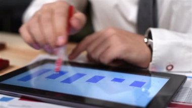 El üstünde perde Finans raporu grafiklerle Tablet ile kullanarak kalem ile tüccar. Yakın çekim