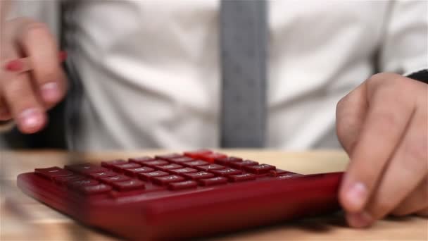 Kırmızı hesap makinesi kullanarak iş adamı ele. İş kavramı. Yakın çekim — Stok video