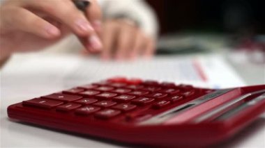 İşadamı gelir hesaplamak için hesap makinesi üzerinde. Ağır çekim etkisi