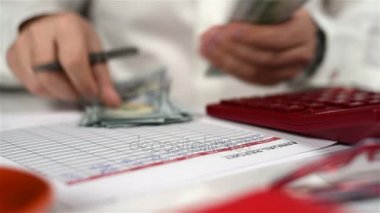 Muhasebeci adam hesap makinesi ile dolar sayar. Bankacılık kavramı. Yakın çekim