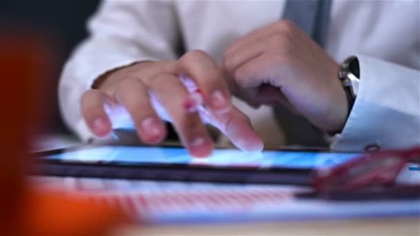 Empresario con la pluma roja en la mano usando la almohadilla táctil con las cartas del informe de las finanzas en pantalla . — Vídeo de stock