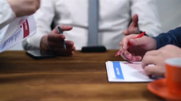 Три бізнесмени сидять в офісі і перевіряють фінансовий звіт — стокове відео