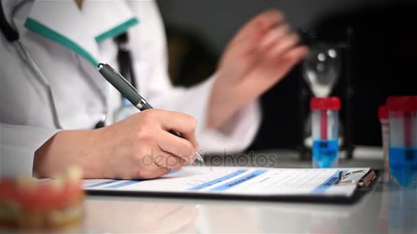 Il medico scrive la prescrizione e fa un'entrata in una scheda medica personale — Video Stock