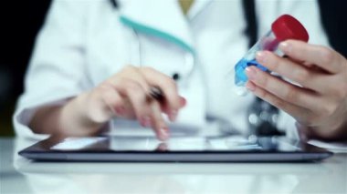 Doktor Test tüpüne kadar tutar ve mavi örnek inceliyor