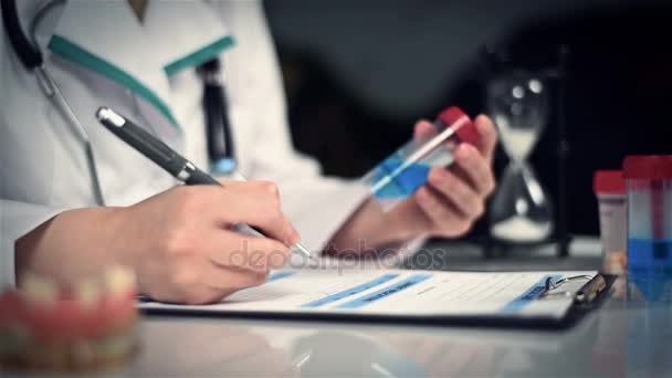 Donna medico scrive prescrizione e fa un'entrata in una scheda medica personale — Video Stock