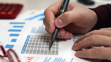 Tüccar elinde kalem ile adam ve Menkul Kıymetler Borsası istatistik analiz eder