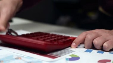 Kırmızı hesap makinesi kullanarak muhasebeci ele. İş kavramı. Yakın çekim
