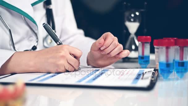 Médico escreve prescrição e faz uma entrada em um cartão médico pessoal — Vídeo de Stock