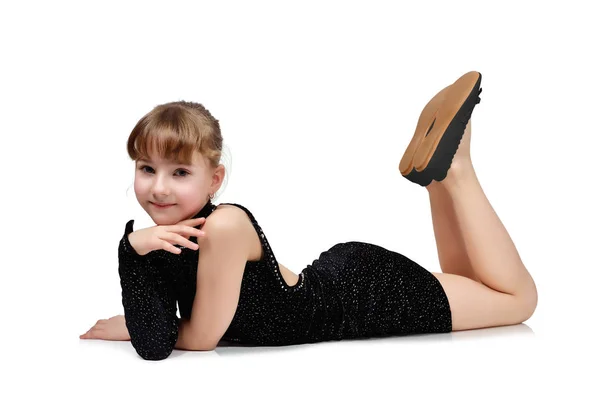 Mooi meisje is liggend op de vloer in een zwarte jurk — Stockfoto