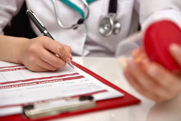 Doctor holding container with tablet — Stock Photo, Image