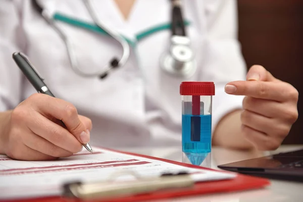 Scientist points his finger to blue sample — Stock Photo, Image