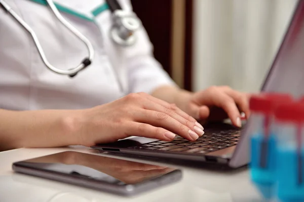 Lekarz rękami pisania na laptopa — Zdjęcie stockowe