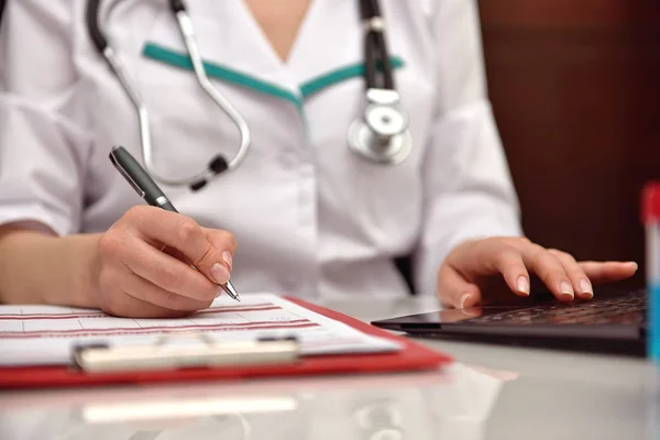 Doctor que llena la historia médica — Foto de Stock