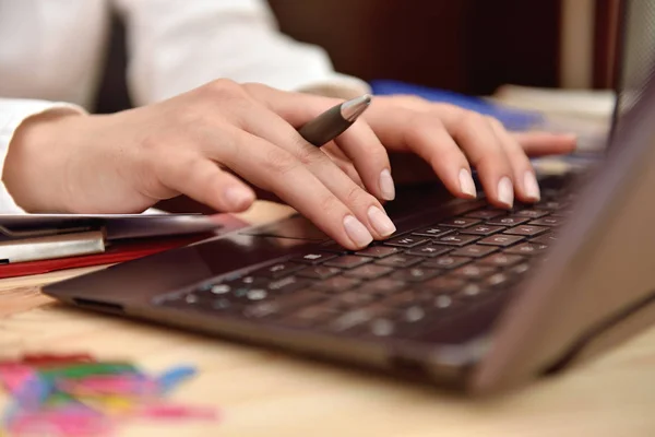 Mão com caneta digitando no laptop — Fotografia de Stock