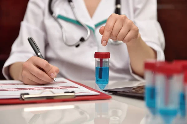 Scientist points his finger to blue sample — Stock Photo, Image