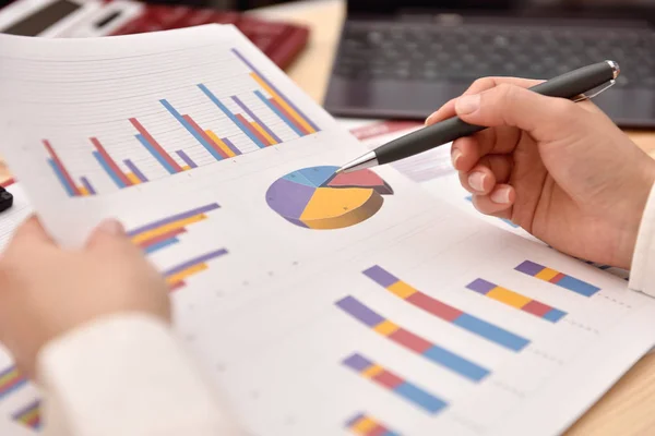 Hand analyzing income graphs and charts — Stock Photo, Image
