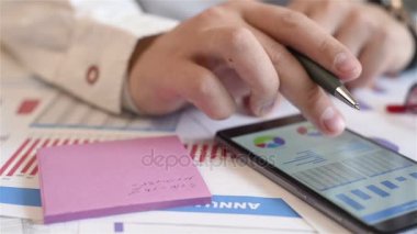 Grafikler ve ekran ve yazar hisse senedi verileri için kağıt üzerinde ile cep telefonuyla tüccar. Ağır çekim etkisi