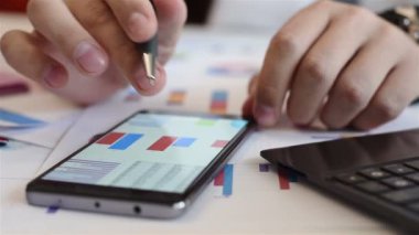 Tüccar gelir Çizelgeler ve grafikler cep telefonu ekran üzerinde analiz. İş kavramı