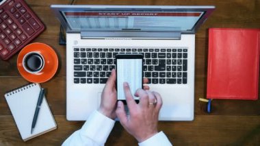 Cep Telefonunuzun ekranında borsa verileri ile iş adamı. Yukarıdan görüntülemek