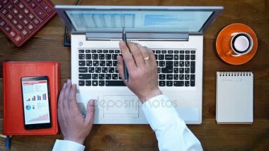 İşadamı yıllık raporu denetler. Hisse senedi verileri ekran laptop. Yukarıdan görüntülemek