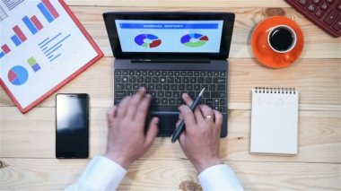 Office, Laptop ve denetimleri yıllık raporu yazmaya çalışan iş adamı